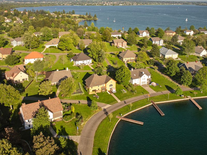 Looking down over a sunny lakeshore neighborhood with docks